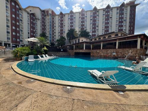 a large swimming pool with lounge chairs and a hotel at Hot Springs Hotels in Caldas Novas