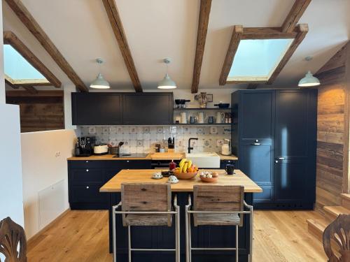 a kitchen with blue cabinets and a wooden counter top at Old barn, hay outside, new inside in Brixen im Thale