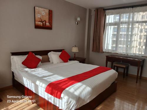 a bedroom with a bed with red pillows and a desk at The Hideout in Nairobi