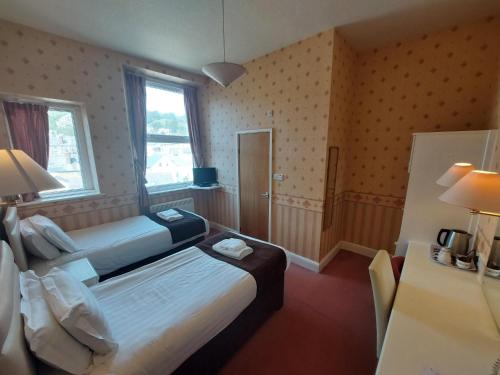 a hotel room with two beds and a window at White Heather Hotel in Llandudno
