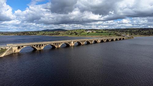 a bridge over the water on a cloudy day at Hotel Alda Guijuelo in Guijuelo