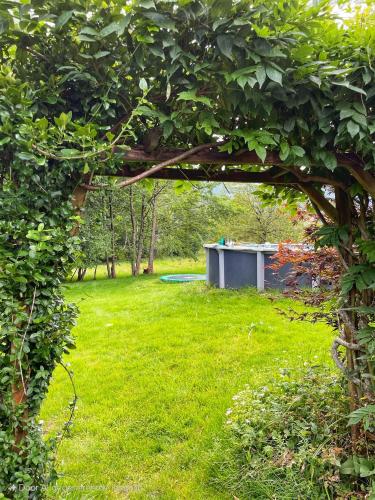 a view of a garden through an arch in the grass at Chalet Notre Retraite in Ventron