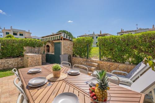 a wooden table with a bowl of fruit on a patio at The Golden Breeze – Beachside Pool & BBQ Escape in Faro