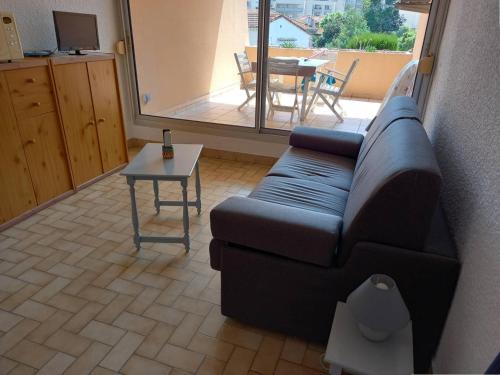 un salon avec un canapé et une table dans l'établissement Studio climatisé avec coin nuit et terrasse plein Sud, 10 m², parking inclus - FR-1-100-194, à Cavalaire-sur-Mer