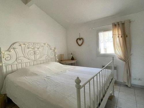 une chambre avec un lit blanc et une fenêtre dans l'établissement Charmant pavillon avec piscine à Valras-Plage, proche plage et commerces, idéal pour 4 personnes - FR-1-701-78, à Valras-Plage