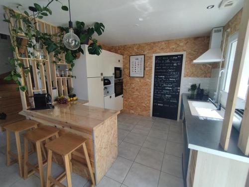 - une cuisine avec une table, des chaises et un tableau noir dans l'établissement Maison Ty Cosy, calme & plage à 10 min, à Ploemel