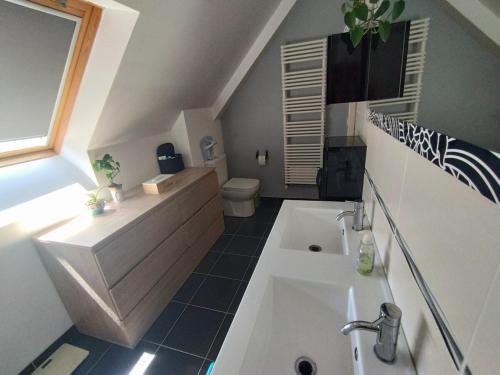 une salle de bain avec une baignoire blanche et un lavabo dans l'établissement Maison Ty Cosy, calme & plage à 10 min, à Ploemel
