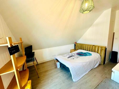 une petite chambre avec un lit et un bureau dans l'établissement Maison Ty Cosy, calme & plage à 10 min, à Ploemel