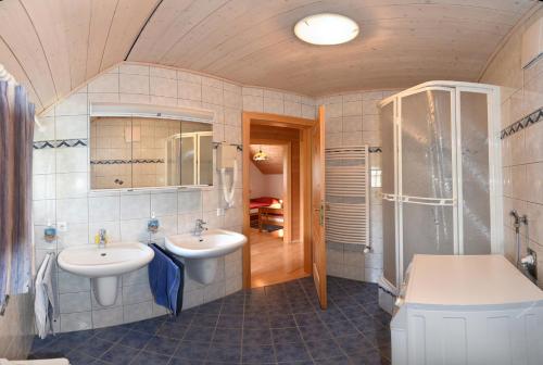 a bathroom with two sinks and a shower at Appartementhaus Parzer in Pruggern