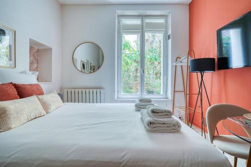 une chambre avec un grand lit blanc avec des serviettes dessus dans l'établissement Studio proche Alesia - Thibaud -III, à Paris