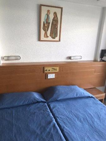 a bedroom with a blue bed and a picture on the wall at Cornelia Hotel Ayia Napa Center in Ayia Napa