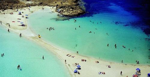a group of people in the water at a beach at Cornelia Hotel Ayia Napa Center in Ayia Napa