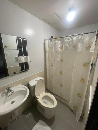 a bathroom with a white toilet and a sink at A Venue Residences 1509 in Makati