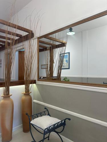 a bench in a room with two vases and a mirror at Apart Bosch House in Vicente López