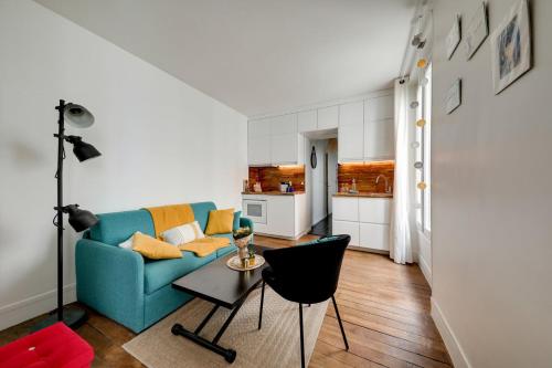 un salon avec un canapé bleu et une table dans l'établissement Mon Précieux, à Paris