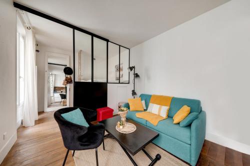 un salon avec un canapé bleu et une table dans l'établissement Mon Précieux, à Paris