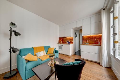 un salon avec un canapé bleu et une table dans l'établissement Mon Précieux, à Paris