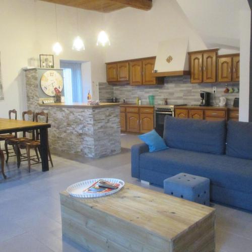 un salon avec un canapé bleu et une cuisine dans l'établissement Maison entre CORBIÈRES et MINERVOIS, à Escales