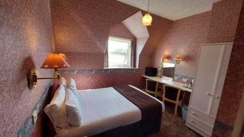 a hotel room with a bed and a window at White Heather Hotel in Llandudno