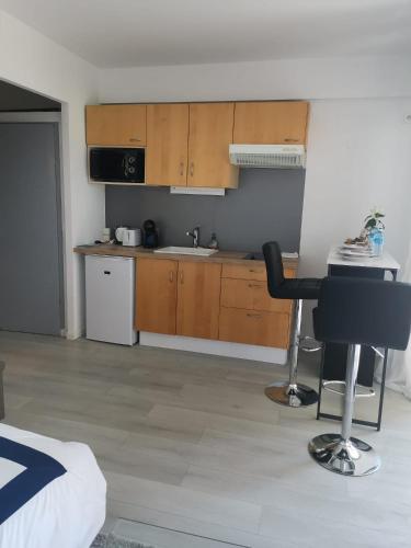 une cuisine avec des placards en bois, une table et une chaise dans l'établissement joli studio près de la mer, à Mandelieu-la-Napoule