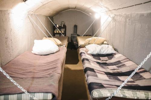 two beds in a tent in a room at Pinčiukas Bunkeris in Dagiai