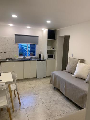 a living room with a bed and a kitchen at Esquel Home in Esquel
