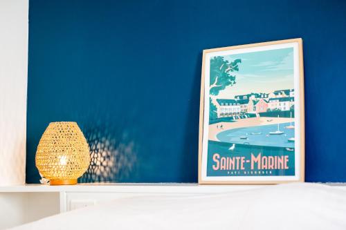 a framed picture of the beach on a shelf at Appartement sainte marine vue mer in Combrit