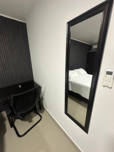 a mirror on a wall with a bed in a room at Apartahotel Plaza in San Andrés