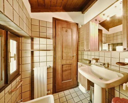 a bathroom with a sink and a wooden door at Appartamento Dante in Moniga