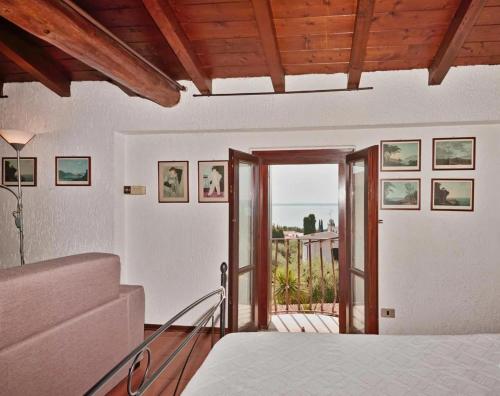 a bedroom with a bed and a balcony at Appartamento Dante in Moniga