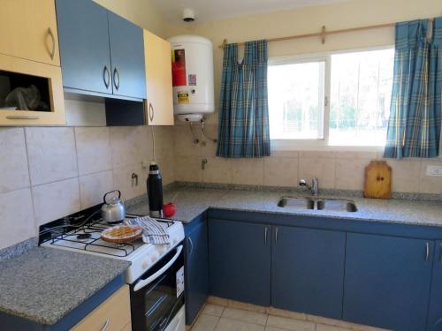 La Estanciaにあるcasa de campo a metros del lagoのキッチン(青いキャビネット、コンロ付)