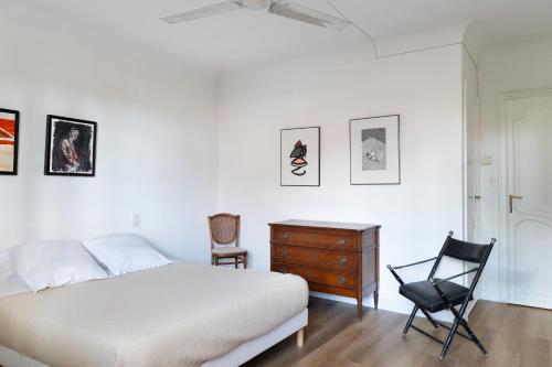 a bedroom with a bed and a chair and a dresser at Maison Alta Mar - 7 Chambres & Jacuzzi in Collioure