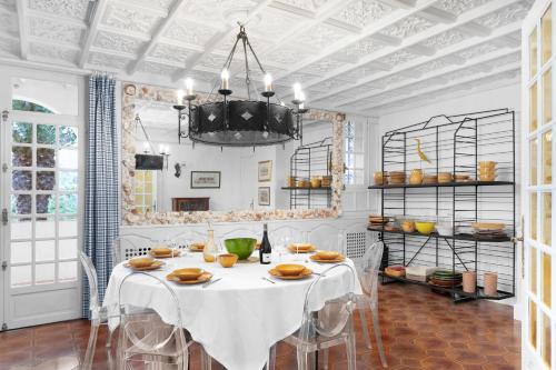 a dining room with a table with chairs and a chandelier at Maison Alta Mar - 7 Chambres & Jacuzzi in Collioure