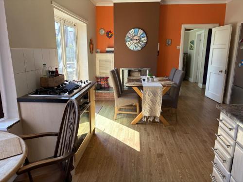 a kitchen with a table and a kitchen with orange walls at Lilac Villa Skegness in Skegness