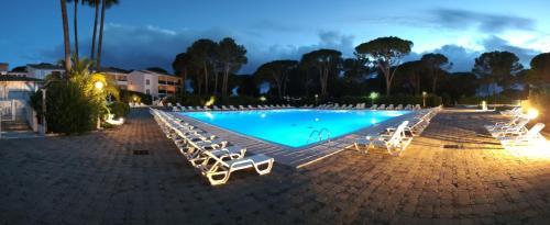 - une piscine entourée de chaises longues blanches dans l'établissement Grand T3 climatisé à Saint Raphaël Valescure, à Saint-Raphaël