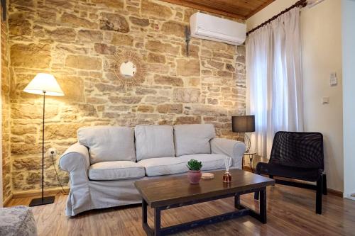a living room with a couch and a stone wall at Alexandrino in Chios