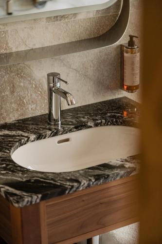 a bathroom counter with a sink and a bottle of soap at Forest Hotel in Kraków