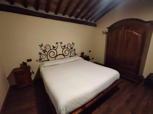 a bedroom with a bed with a wooden headboard at B&B IL Giardino del Borgo in Veiano