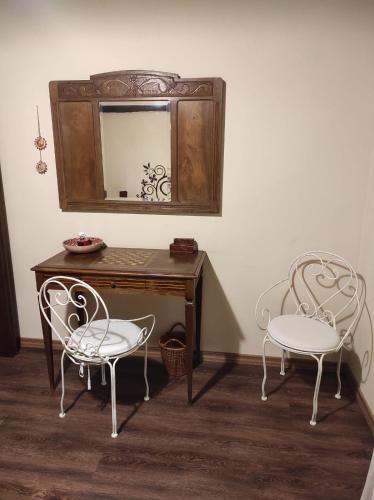 two chairs sitting next to a wooden table with a mirror at B&B IL Giardino del Borgo in Veiano