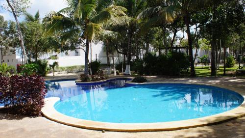uma grande piscina com palmeiras num quintal em La Casa del Mexicano terraza y jardin exoticos 12 min del playa Esmeralda em Playa del Carmen