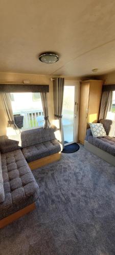 a living room with two beds in a van at 4 Berth Static Caravan Golden Palm Resort with Decking in Chapel Saint Leonards