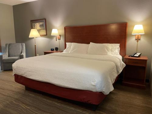 a hotel room with a large bed and a chair at SouthShore Hotel on Lake Bemidji, Trademark Coll by Wyndham in Bemidji