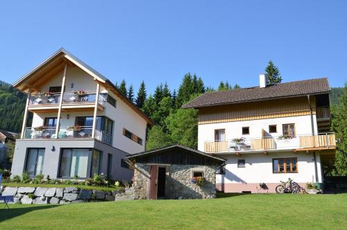 un gran edificio blanco con balcones y patio en Pension Mitterer, en Weissensee