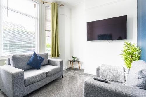 a living room with a couch and a tv at Teesside House - Sleeps up to 10 in Redcar