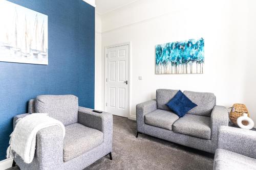 a living room with two chairs and a couch at Teesside House - Sleeps up to 10 in Redcar