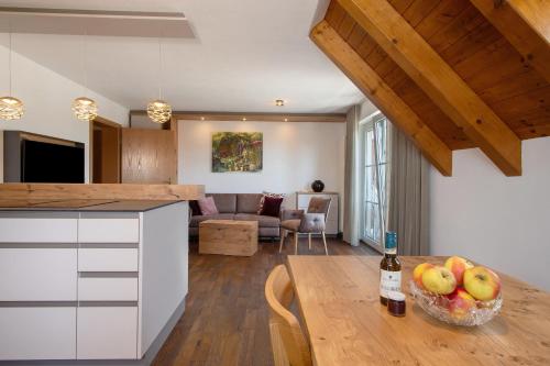a kitchen and living room with a table with a bottle of wine at Obst- und Ferienhof Lehle in Immenstaad am Bodensee