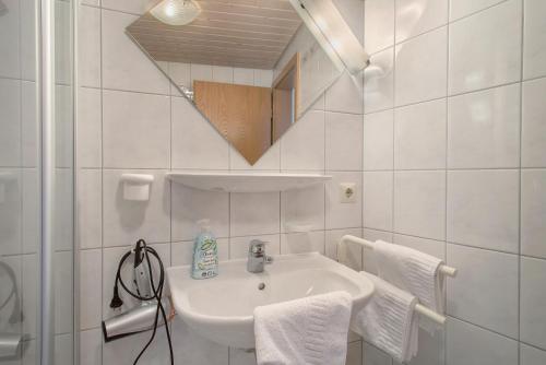 a white bathroom with a sink and a mirror at Obst- und Ferienhof Lehle in Immenstaad am Bodensee