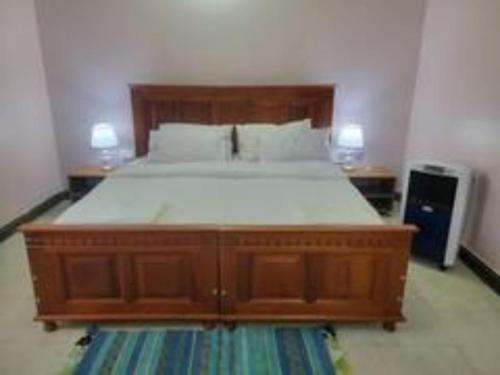 a bedroom with a large wooden bed in a room at Biira Transit Residence Entebbe with free airport pickup in Entebbe