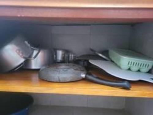 a shelf with a bunch of kitchen utensils on it at Biira Transit Residence Entebbe with free airport pickup in Entebbe