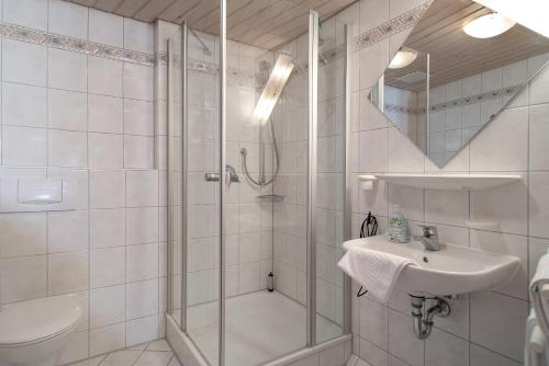 a white bathroom with a shower and a sink at Obst- und Ferienhof Lehle in Immenstaad am Bodensee